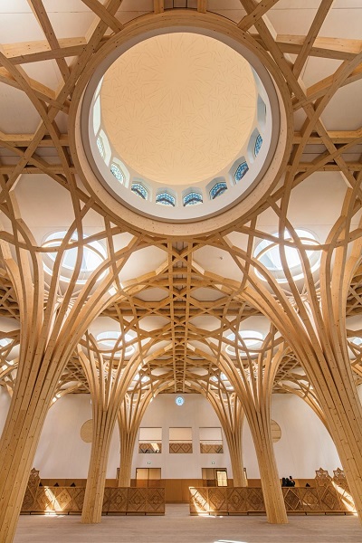 Изящно изогнутые и переплетенные древесные колонны образуют свод главного молитвенного зала Центральной мечети в Кембридже