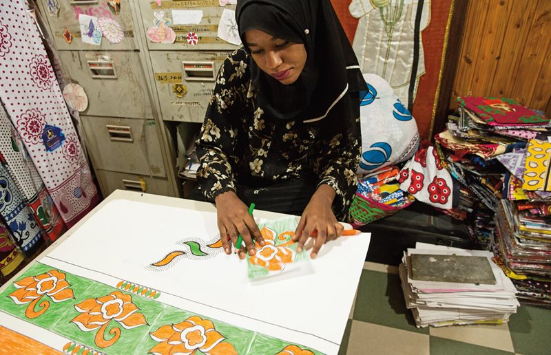Дизайнер фирмы Chavda 24-летняя Сабрина Али создала многие из самых смелых и самых популярных канг. Окруженная стопками образцов тканей, она придумывает и рисует новые орнаменты
