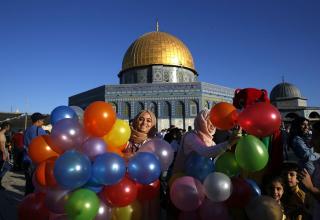Иерусалим. Палестинка с праздничными шариками на фоне святилища Купол скалы рядом с мечетью аль-Акса
