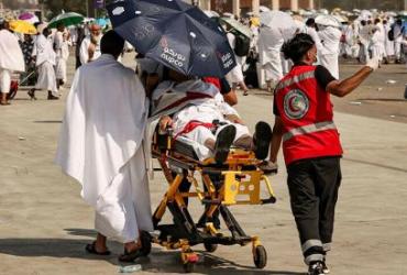 Члены медицинской бригады эвакуируют мусульманского паломника, пострадавшего от сильной жары, у подножия горы Арафат, также известной как Джабаль ар-Рахма или Гора Милосердия, во время ежегодного хаджа 15 июня