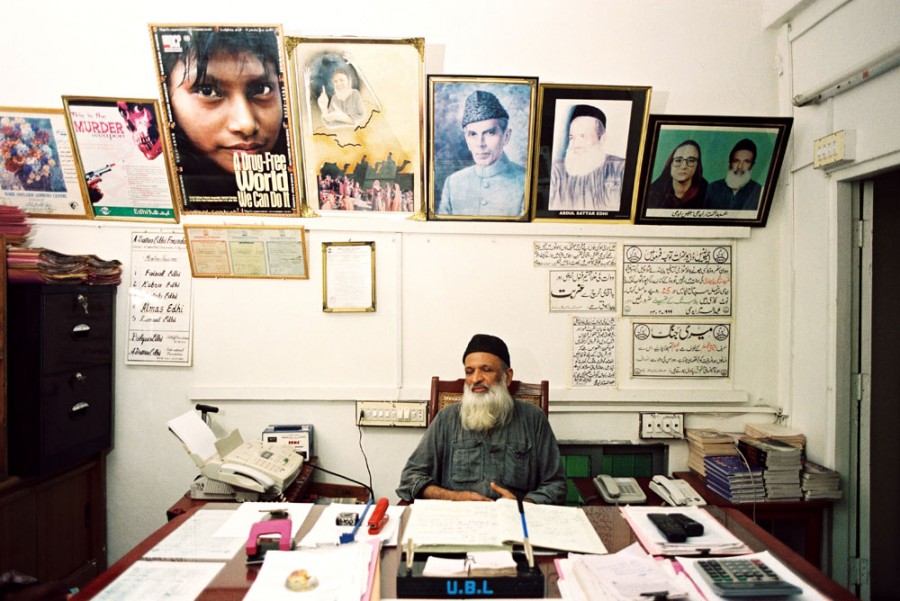 Август 2004 г. Абдул Саттар Эдхи сидит за столом в своем кабинете в районе Митхадар, Карачи. Кабинет находится в том же здании, где в 1951 году он открыл свою первую аптеку. На звонки с просьбами он отвечает лично.