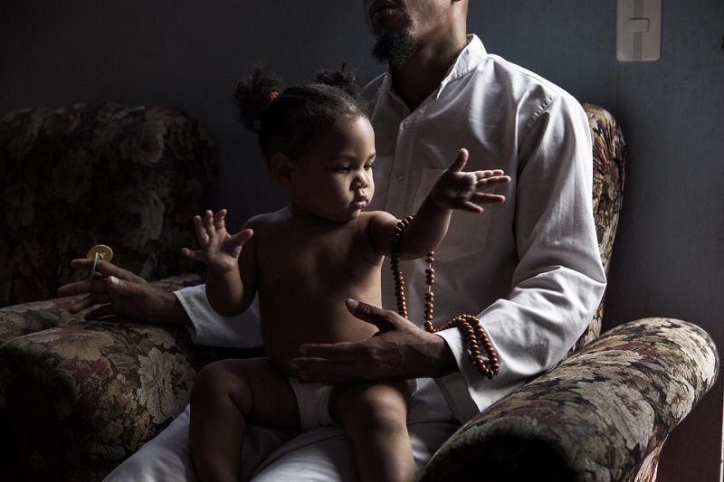 Ярима играет с четками на коленях у отца, 33-летнего Али. Али с женой приняли ислам в 2014 году. Ярима – одна из первых кубинских детей, родившихся в исламе