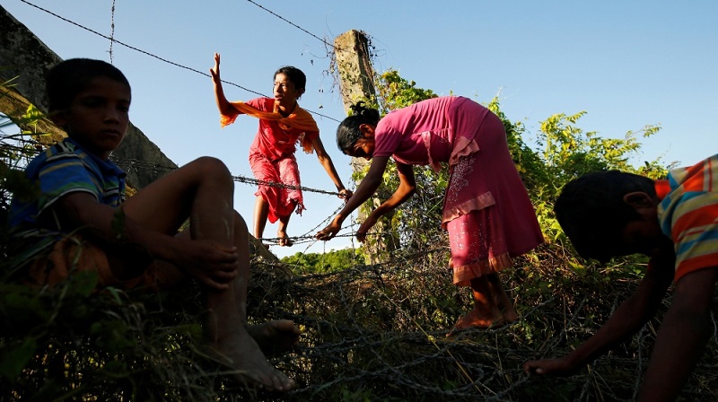 Дети рохинья преодолевают заграждение на границе между Мьянмой и Бангладеш, пытаясь попасть в Бандарбан, Бангладеш