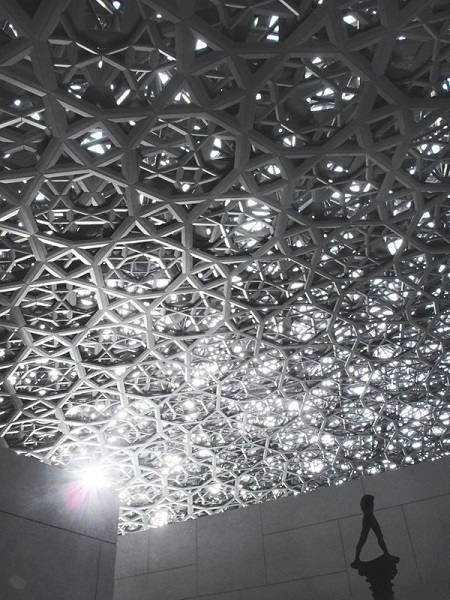 Восьмислойный кружевной орнамент из более 8 тысяч переплетенных между собой колец создает игру света, пронизывающего купол, а «Идущий человек» Огюста Родена под ним усиливает ощущение близости неба