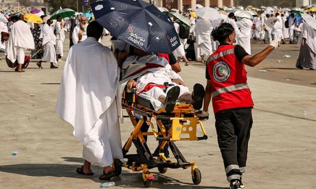 Члены медицинской бригады эвакуируют мусульманского паломника, пострадавшего от сильной жары, у подножия горы Арафат, также известной как Джабаль ар-Рахма или Гора Милосердия, во время ежегодного хаджа 15 июня