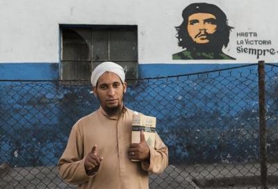 28-летний Мохаммед Дауд, обращенный кубинец, напротив стены с портретом Че Гевары