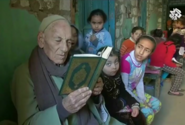 Пожилой египтянин-христианин учит детей Корану