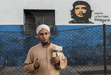 28-летний Мохаммед Дауд, обращенный кубинец, напротив стены с портретом Че Гевары